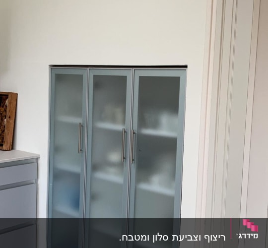ארון עם דלתות זכוכית חלבית ורצפת אריחים אפורה